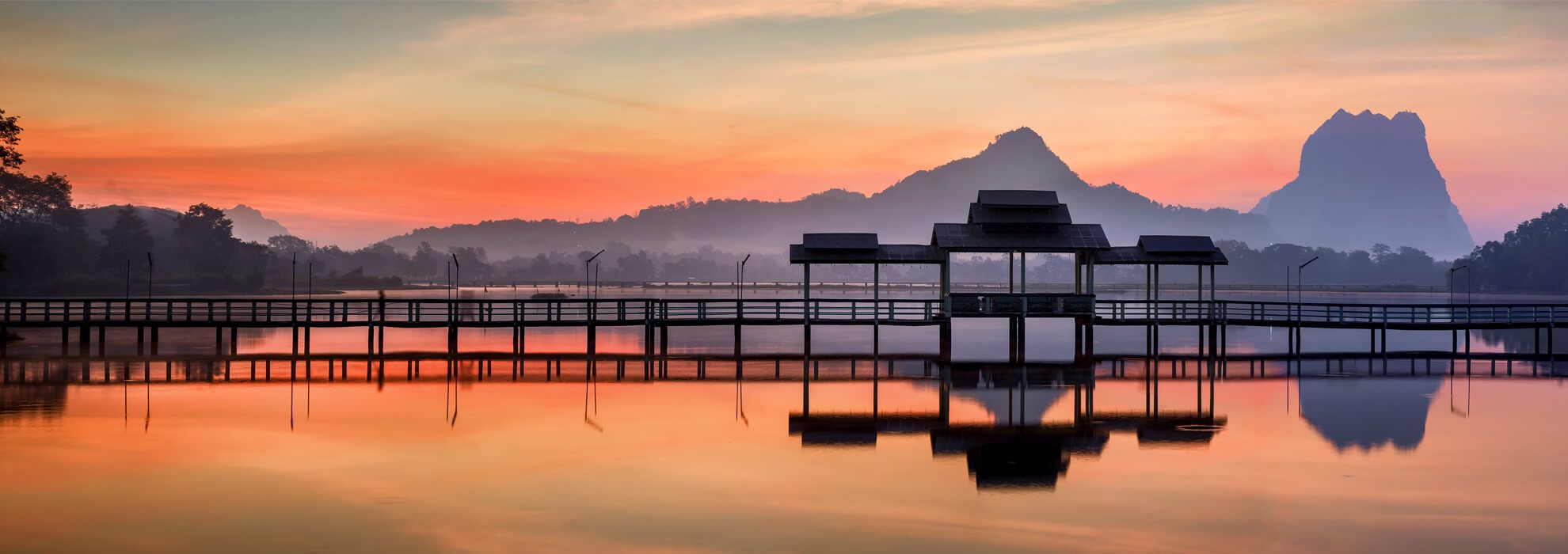 Stege an einem See bei Sonnenaufgang
